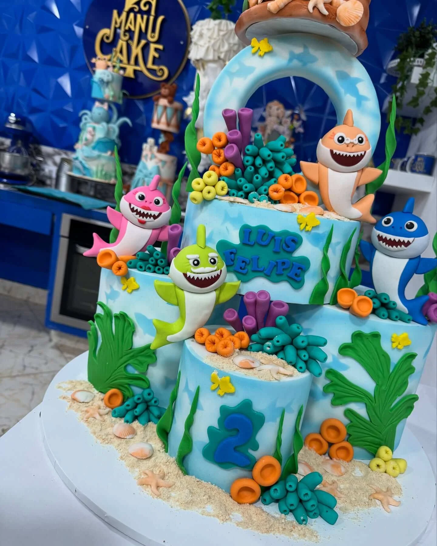 Pastel de cumpleaños con figuras de Baby Shark en fondant para fiestas infantiles.
