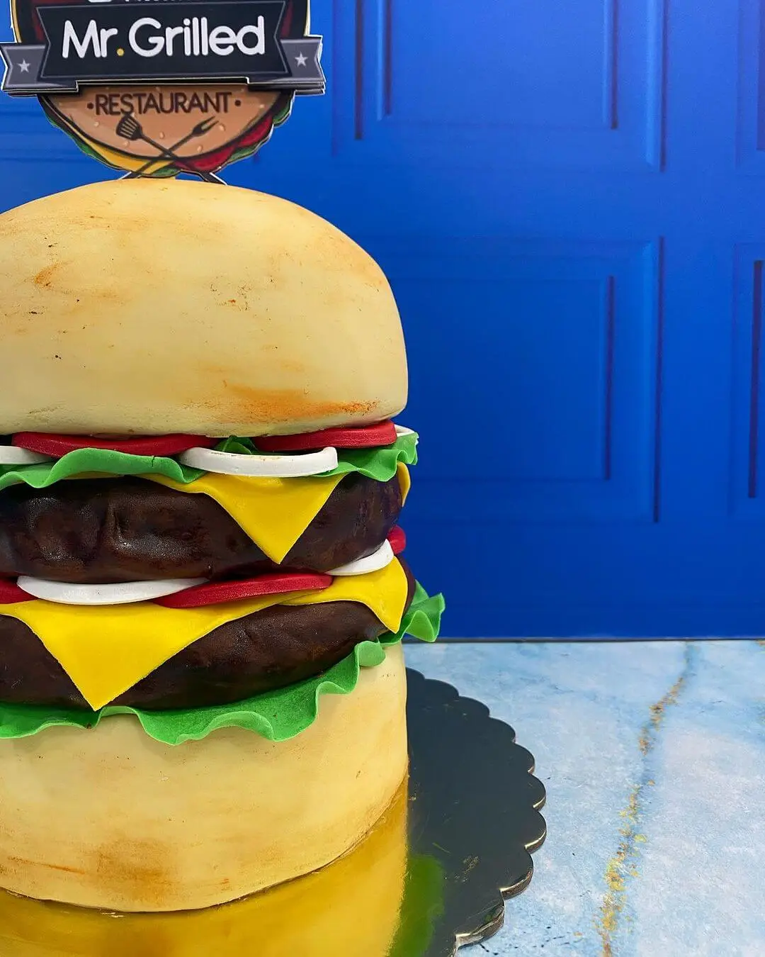 Pastel tallado con forma de hamburguesa, demostrando diseño realista de alimentos.